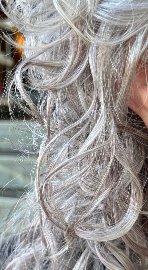Woman with natural silver hair wearing Sara Silvio earrings